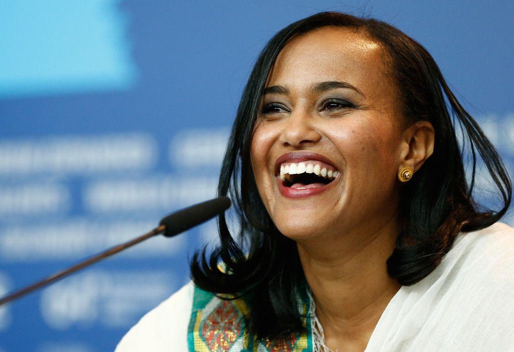 Black woman with shoulder length black air  at microphone smiling
