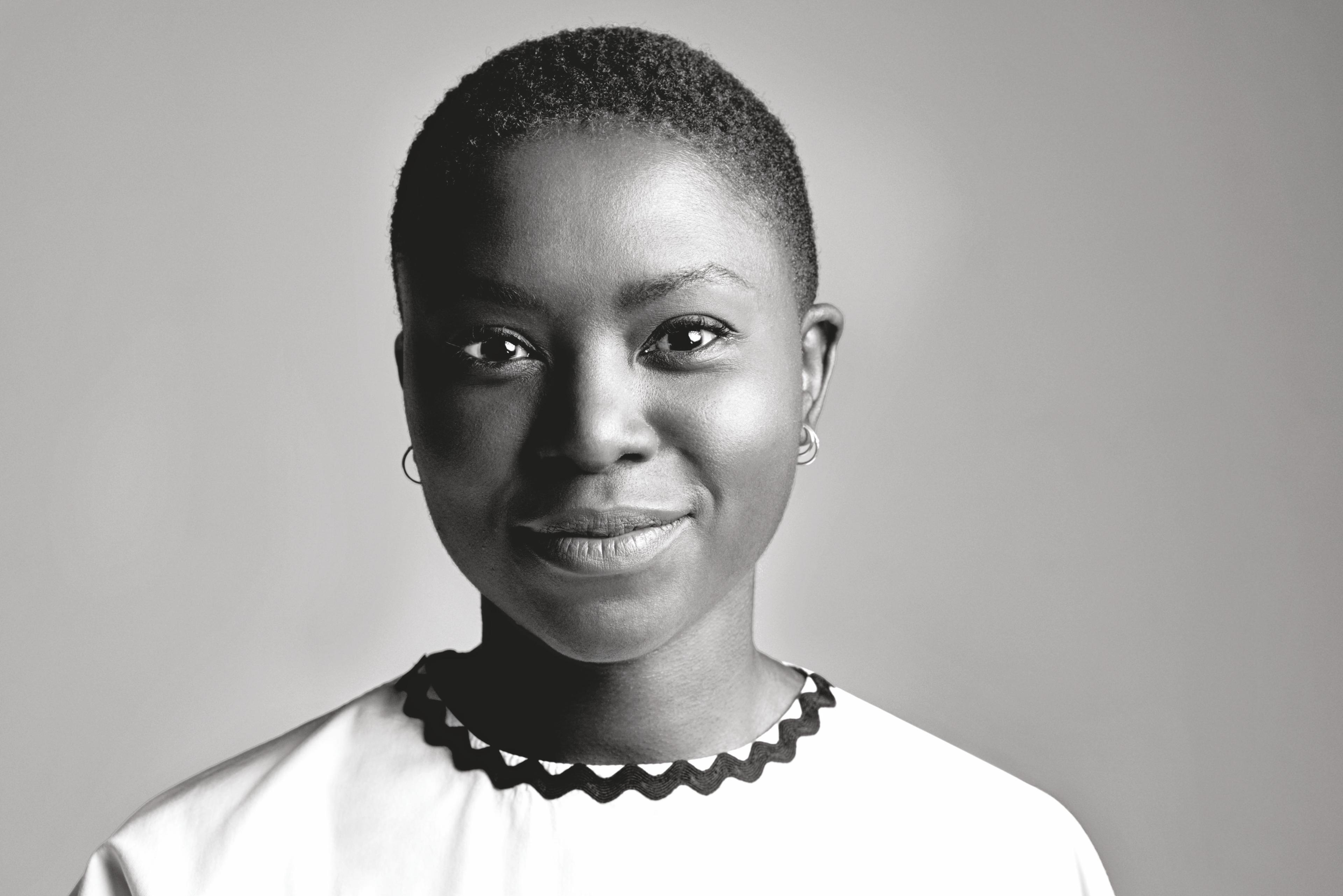 Milisuthando Bongela is looking at the camera, smiling. Black and white portrait.